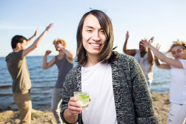 man met drankje - beach game group stockfoto's en -beelden