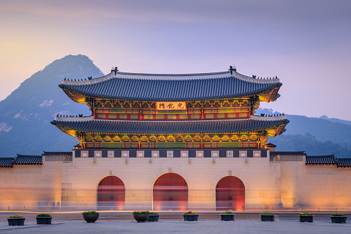 Gyeongbokgung Palace At Twilight Sunset In South Korea, with the name of the palace 'Gyeongbokgung' on a sign