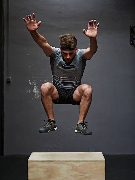 gym jumping on box gym jumping on box in gym cross training stock pictures, royalty-free photos & images