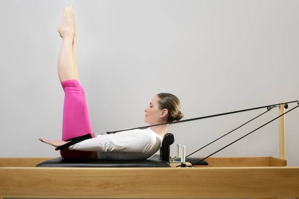 gym woman pilates stretching sport in reformer bed stock photo