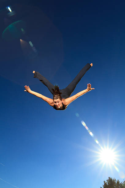 Gymnast Flying in Air with Sun Flare stock photo