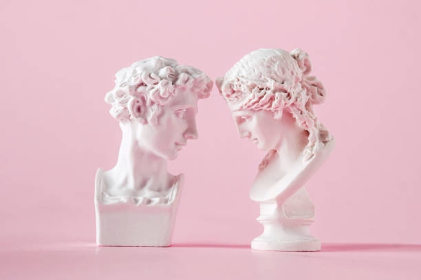 gypsum antique bust of man and woman on pink background, concept of love trust and valentine's day stock photo