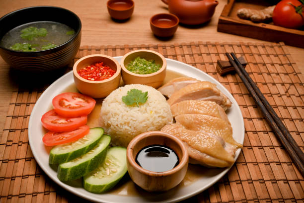 Hainanese chicken rice is served with chicken soup or broth and chopsticks stock photo