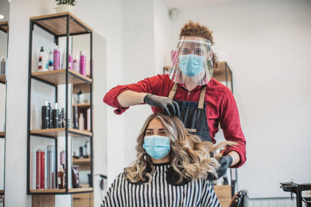 Hair cutting during pandemic Young woman have hair cutting at hair stylist during pandemic isolation, they both wear protective equipment cutting hair stock pictures, royalty-free photos & images
