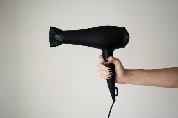 Hair dryer in woman's hand stock photo
