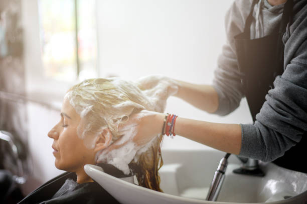 haar wassen in kapsalon - woman washing hair stockfoto's en -beelden