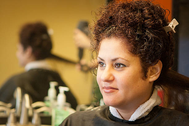 Hairdresser Straightens Customer's Hair stock photo