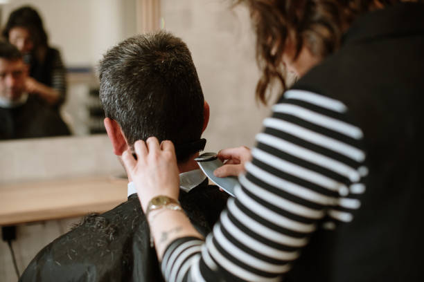 Hairdresser working on a male customer's hair stock photo