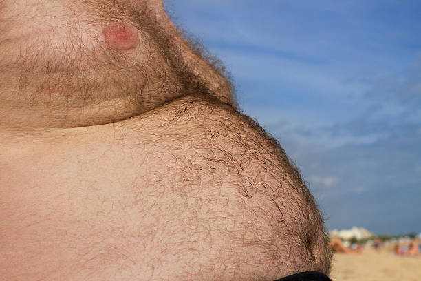 hairy stomach. - fat man beach stock photos and pictures.