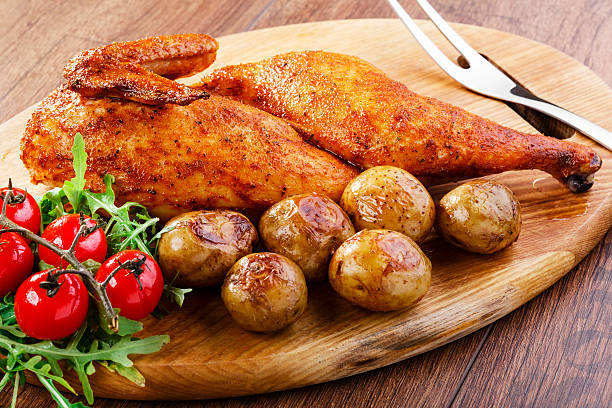 half baked chicken with new potatoes stock photo
