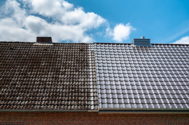 A half cleaned house roof shows the before and after effect of a roof cleaning. stock photo
