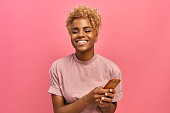 istock Half length shot of positive attractive female model with Afro haircut, feels good, uses smartphone device for entertainment and online chatting, surfers social network profile, uses free internet. 1326426267
