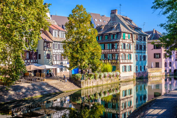 Half-timbered houses reflecting in the canal in the Petite France historic quarter in Strasbourg, France. Strasbourg, France - September 15, 2019: The river Ill canal bathes the Petite France quarter, lined with half-timbered houses reflecting in the still waters under a bright sunshine. petite france strasbourg stock pictures, royalty-free photos & images
