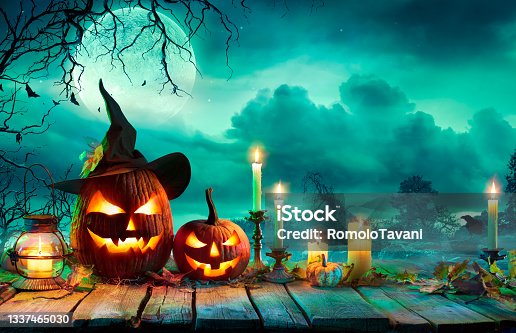 istock Halloween At Night - Pumpkins With Witch Hat And Candles On Table In Mystery Landscape 1337465030