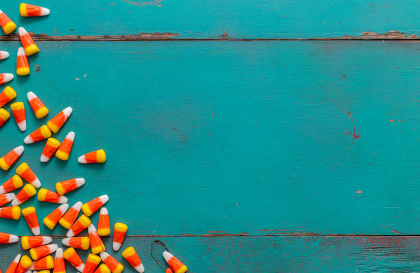 Pile of Halloween candy corn on rustic wood background with copy space.