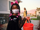 ハロウィーンの子供たちは、フェイスマスクを着用してトリックまたは治療