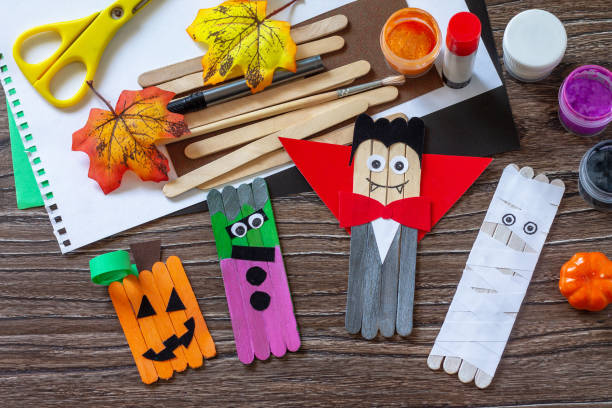 Halloween ghost, pumpkin, mummy and vampire toy gift stics puppets on wooden table. Handmade. Project of children's creativity, handicrafts, crafts for kids. stock photo