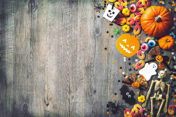 Halloween holiday background Halloween holiday background with skull, skeleton, spiders, pumpkins and candy. View from above candy photos stock pictures, royalty-free photos & images