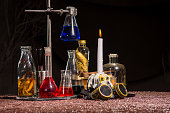 Halloween. Medieval alchemist's table. Flasks with multi-colored liquids. Scientist-encyclopedist room interior. Old reconstruction
