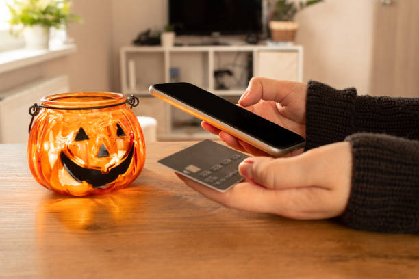 Halloween online shopping, sales and discounts promotions on mobile phone Halloween online shopping, sales and discounts promotions during the spooky day. Online shopping at home in october. Black fridays sale halloween marketing stock pictures, royalty-free photos & images