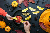 Halloween table setting with red salsa and bat shape tortilla chips, kids party simple snack recipe idea, top down view