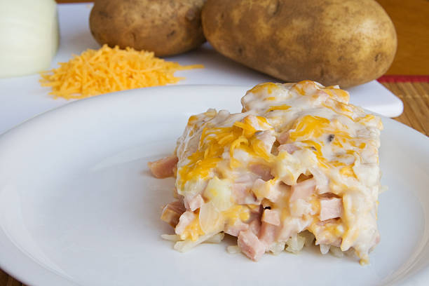 Ham and Hash Brown Casserole Ham and Hash Brown Casserole on a white plate with some ingredients in the background.Click this link for hash brown stock pictures, royalty-free photos & images
