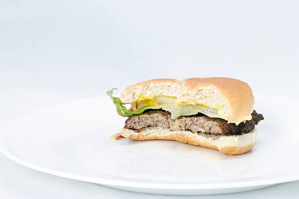 Hamburger bite on a white plate stock photo