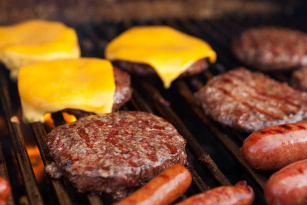 Hamburgers cheeseburgers and hot dogs on grill stock photo