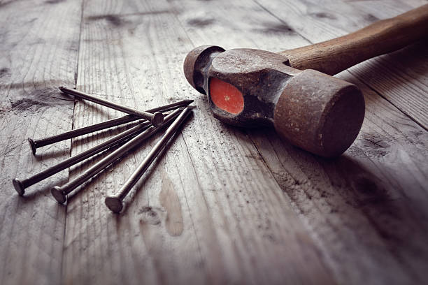 Hammer and nails Hammer and nails on floorboards concept for construction, diy, tools and home improvement nail work tool stock pictures, royalty-free photos & images