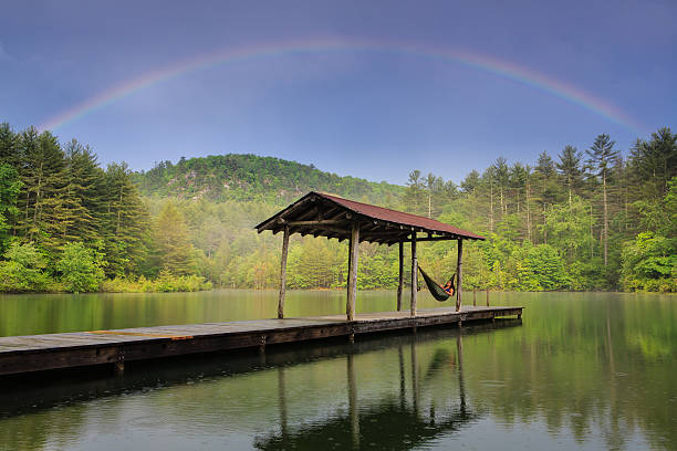 Hammock and rainbow on lake stock photo