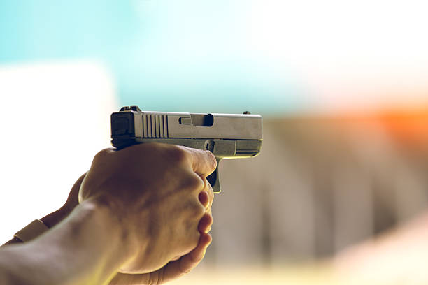 hand aim pistol in academy shooting range - vuurwapen stockfoto's en -beelden