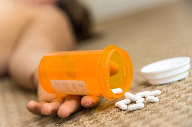A hand at the floor holding a box with drugs woman lying on the floor unconscious  after taking prescription drugs xanax pill stock pictures, royalty-free photos & images