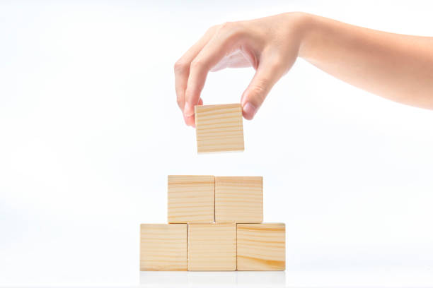 Hand build a pyramid from a wooden block stock photo