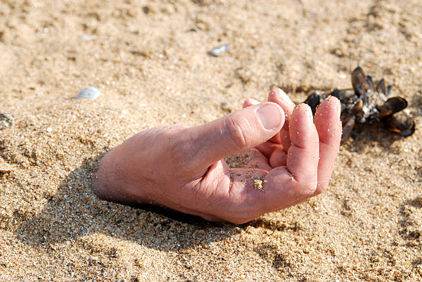 hand burried in the sand stock photo