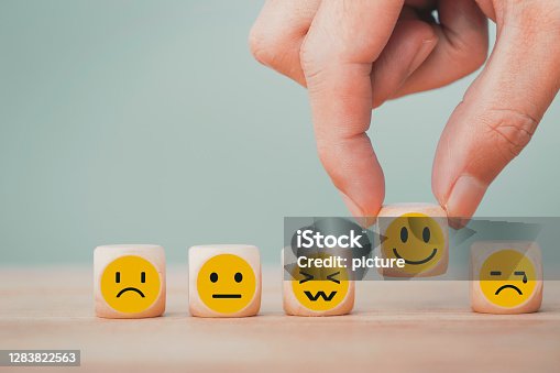 istock Hand chooses with happy smile face emoticon icons on Wooden Cube , good feedback rating for customer review survey 1283822563