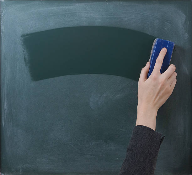 Hand cleaning blackboard with chalkboard rubber Teacher cleaning the chalkboard, suits horizontal composition writing slate stock pictures, royalty-free photos & images