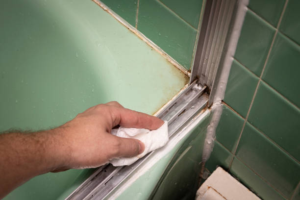 Hand cleaning vintage sliding shower door track stock photo