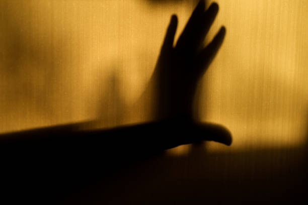 A hand gesture showing refusal in silhouette on the wall stock photo