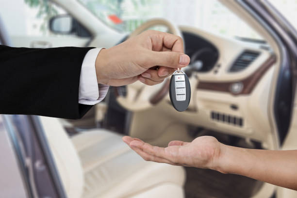 Hand giving and receiving car key remote, with modern car backgrounds Hand giving and receiving car key remote, with modern car backgrounds second hand sale stock pictures, royalty-free photos & images