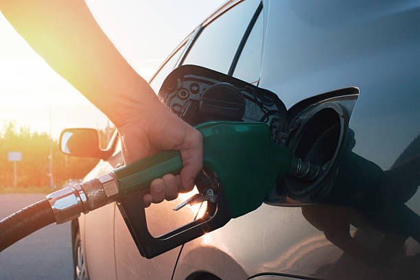 hand guiding the fuel in the car - tanken stockfoto's en -beelden