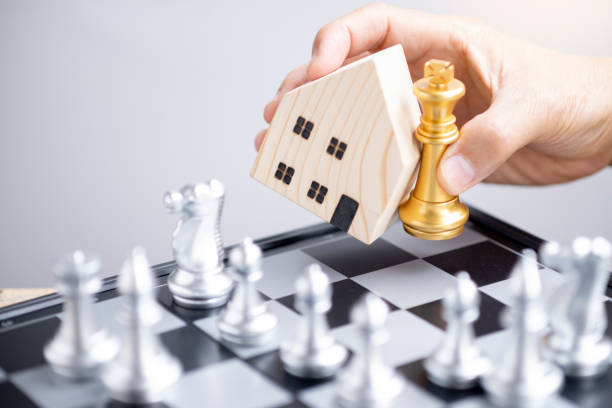 Hand hold  house model and gold king  chess stock photo