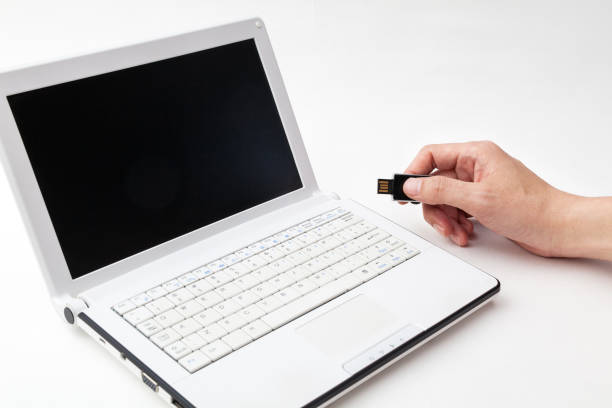Crop hand connecting a USB drive into a laptop