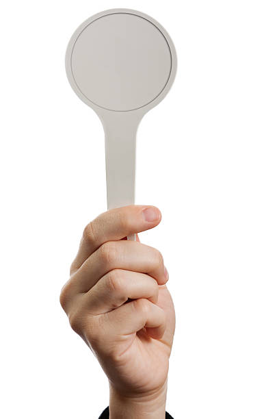 A hand holding a blank auction paddle stock photo