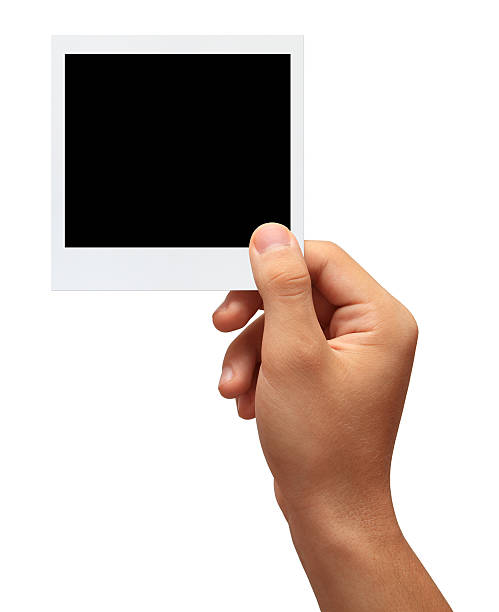 Hand holding a blank photo Hand holding a blank photo in front of white background.Studio shot isolation on white.With clipping path human hand photos stock pictures, royalty-free photos & images
