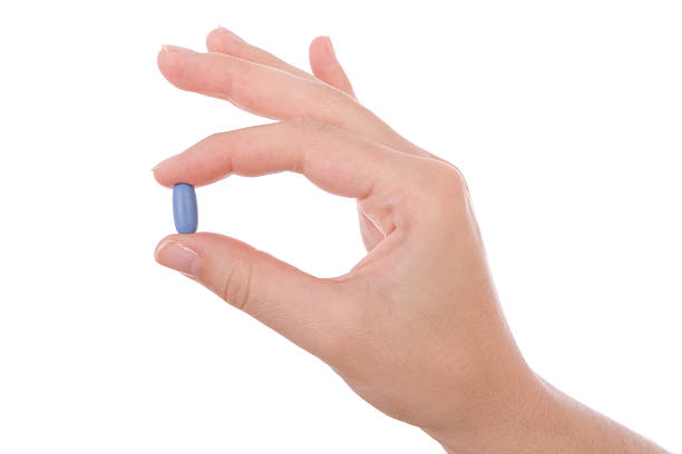 Hand holding a blue pill against impotency  anti impotence tablet stock pictures, royalty-free photos & images