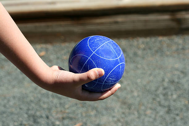 Hand holding a bocce ball stock photo