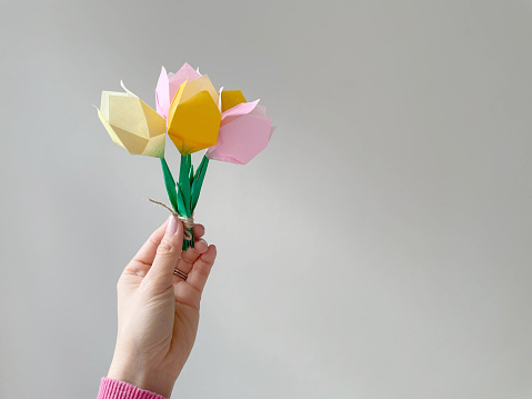 Woman hand holding a bunch of origami tulip flowers