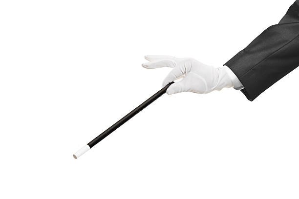 Hand holding a magic wand Hand holding a magic wand isolated on white background magician stock pictures, royalty-free photos & images