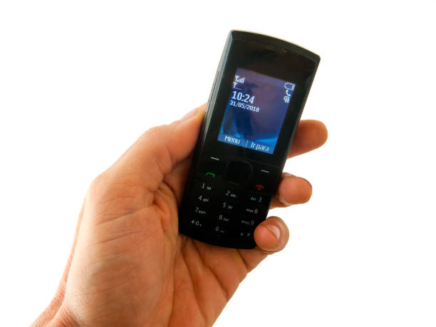 Hand holding an old style cel phone with white background - disconnected unplugged no smartphone stock photo