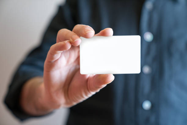 hand holding blank white credit card mockup front side view. plastic bank-card design mock up - segurar imagens e fotografias de stock